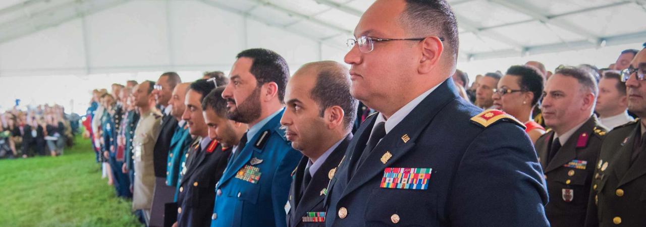 Officers standing in rows at a National Defense University graduation ceremony