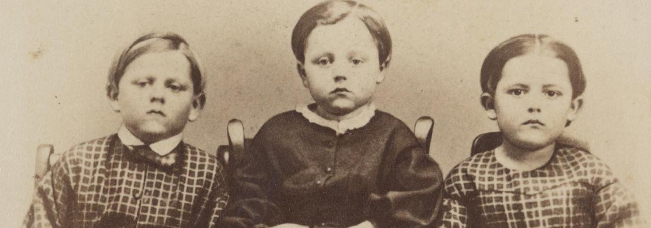 A photograph of three children labeled Frank, Frederick and Alice