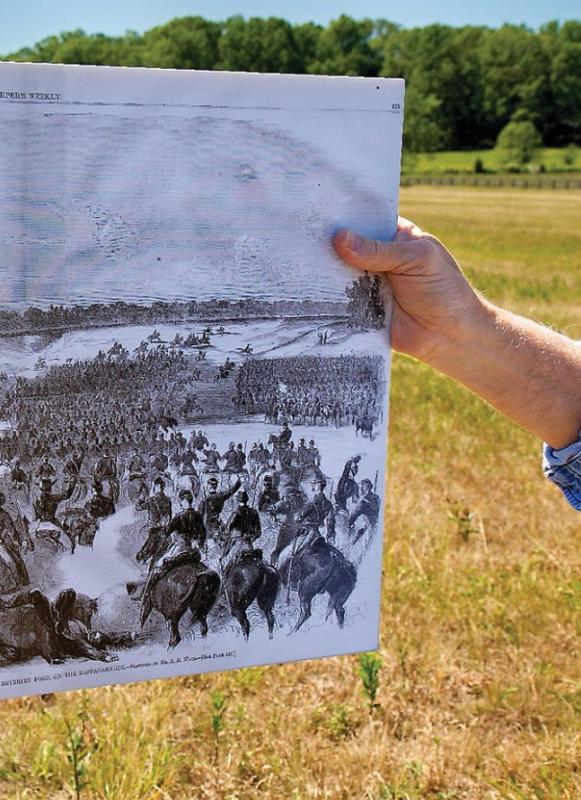 A hand holds an illustration of the Battle of Brandy Station at Brandy Station Battlefield, Va.