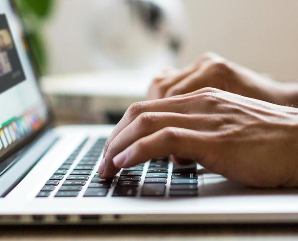 An online participant watches a webinar on their laptop.