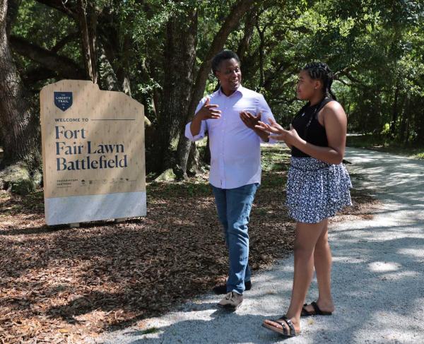 VIsitors walk past a marker at Fort Fair Lawn Battlefield, S.C.