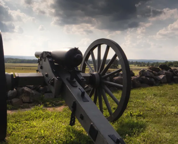 This photograph depicts a cannon resting on a battlefield.