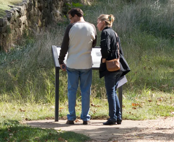 This photo depicts two people learning about Fredericksburg while walking on the grounds of this battlefield.