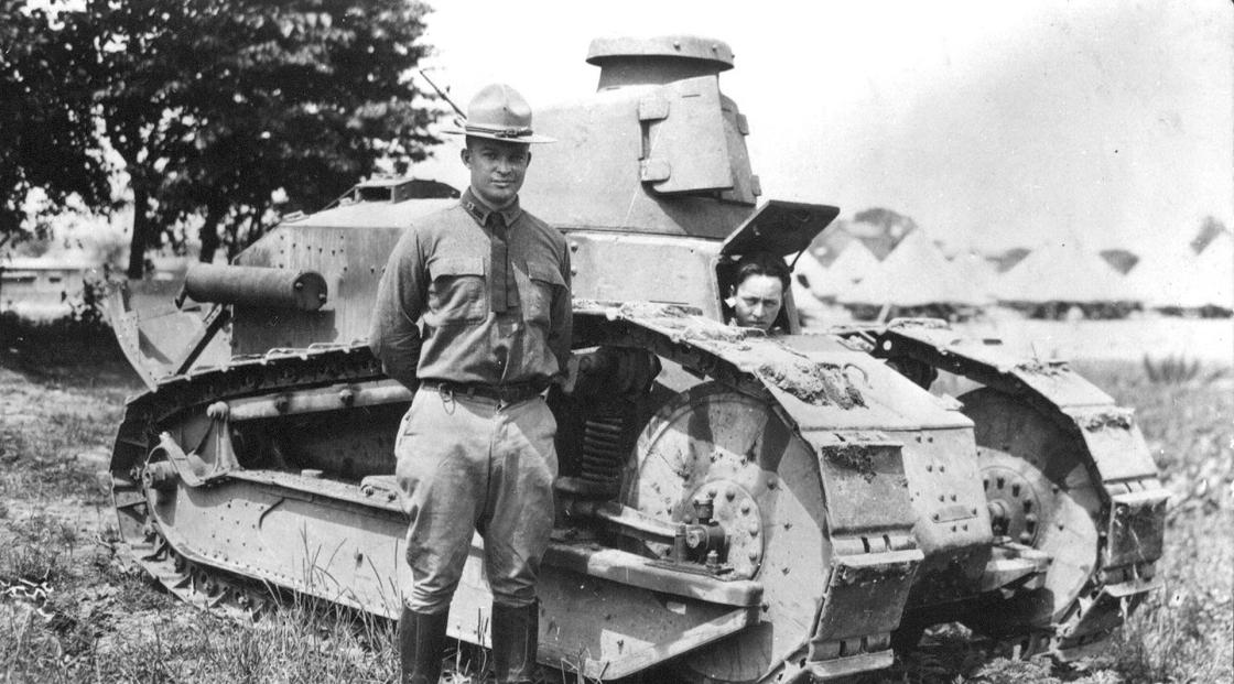 A black and white photo of Maj. Dwight D. Eisenhower beside a Renault light tank